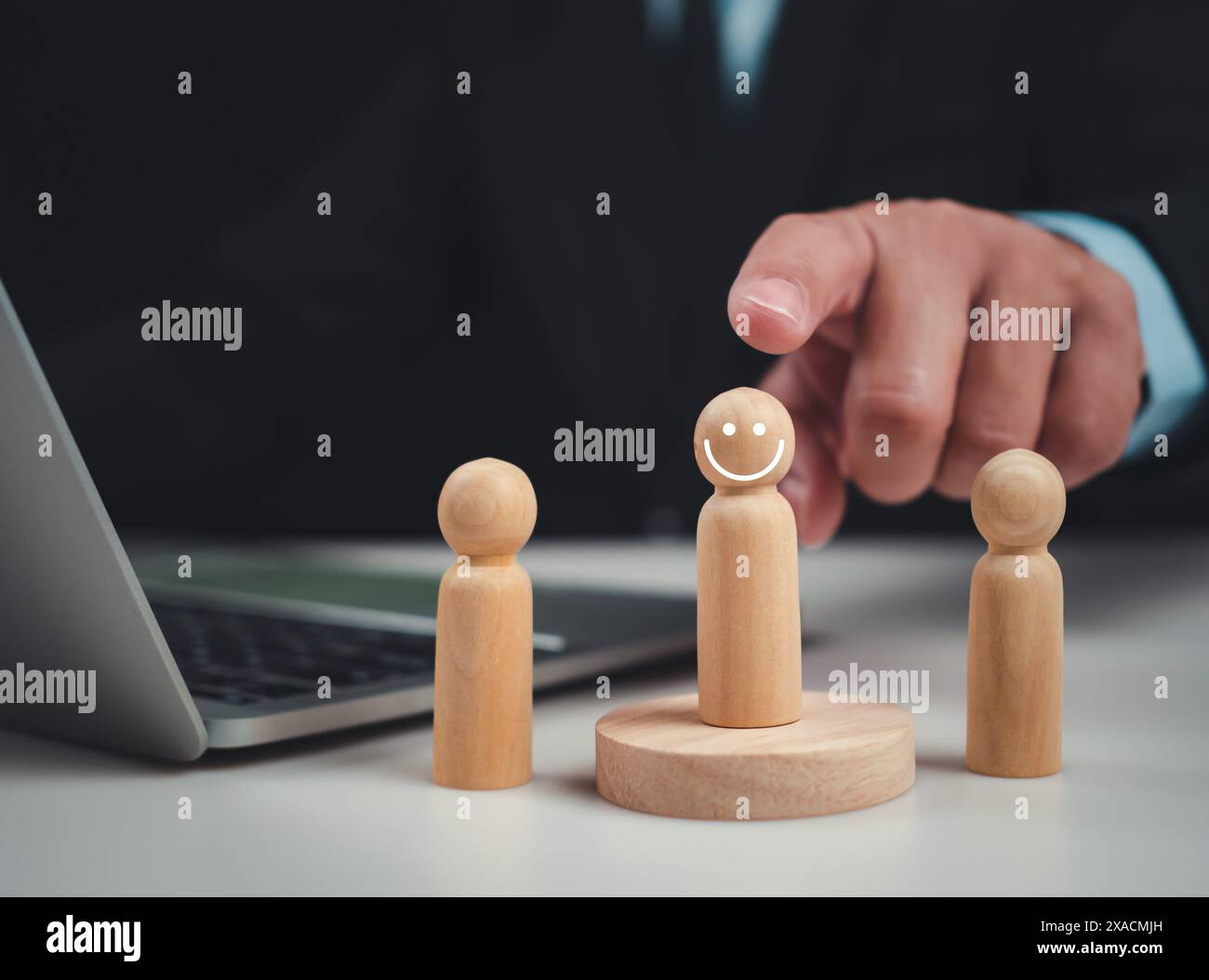 Businessmen pointing to the wooden doll, Screening employee information, Effective personnel management in the organization, Human resources managemen Stock Photo