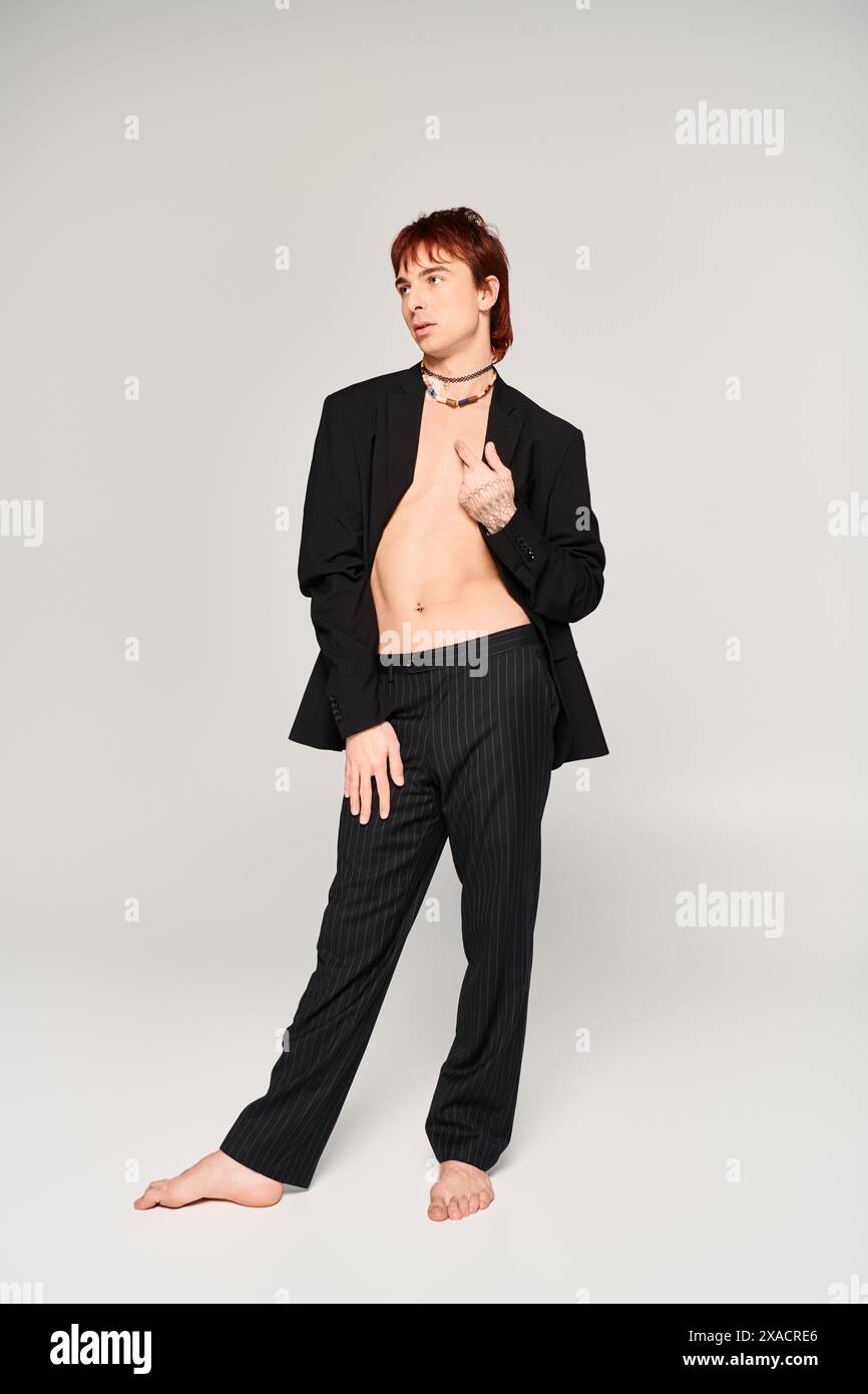 A stylish young man poses confidently in a studio, wearing a suit ...