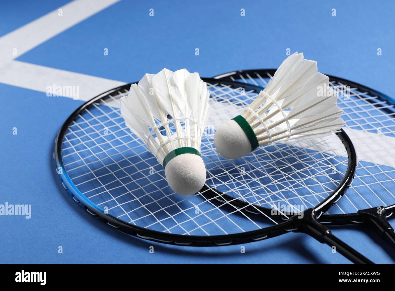 Feather badminton shuttlecocks and rackets on blue background, closeup Stock Photo
