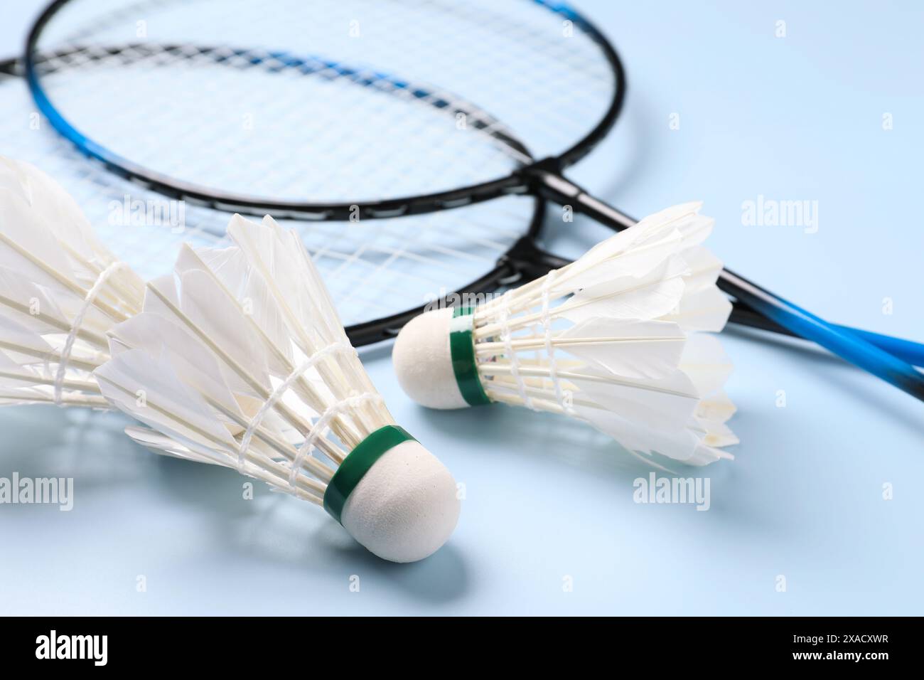 Feather badminton shuttlecocks and rackets on light blue background, closeup Stock Photo