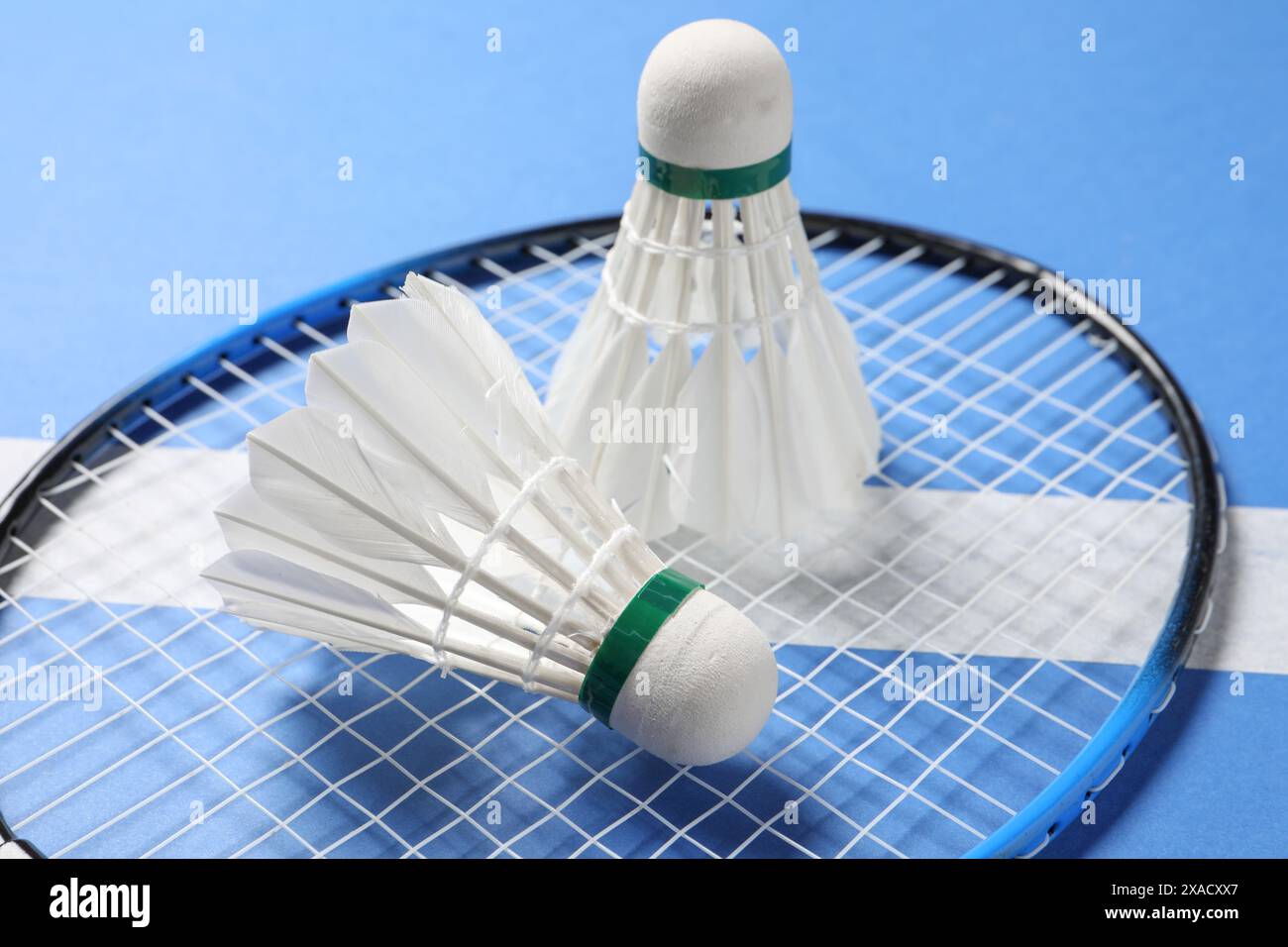 Feather badminton shuttlecocks and racket on blue background, closeup Stock Photo