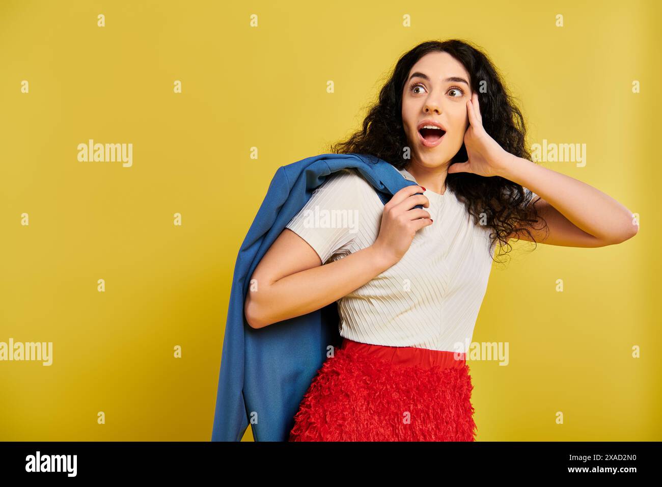 A young brunette woman with curly hair poses wearing a red skirt and ...
