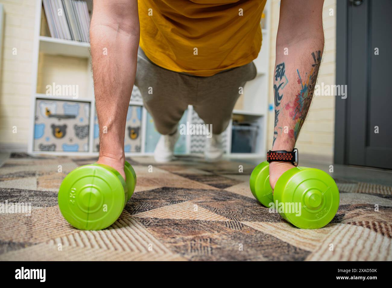 Man Doing Push Ups With Dumbbells At Home Stock Photo