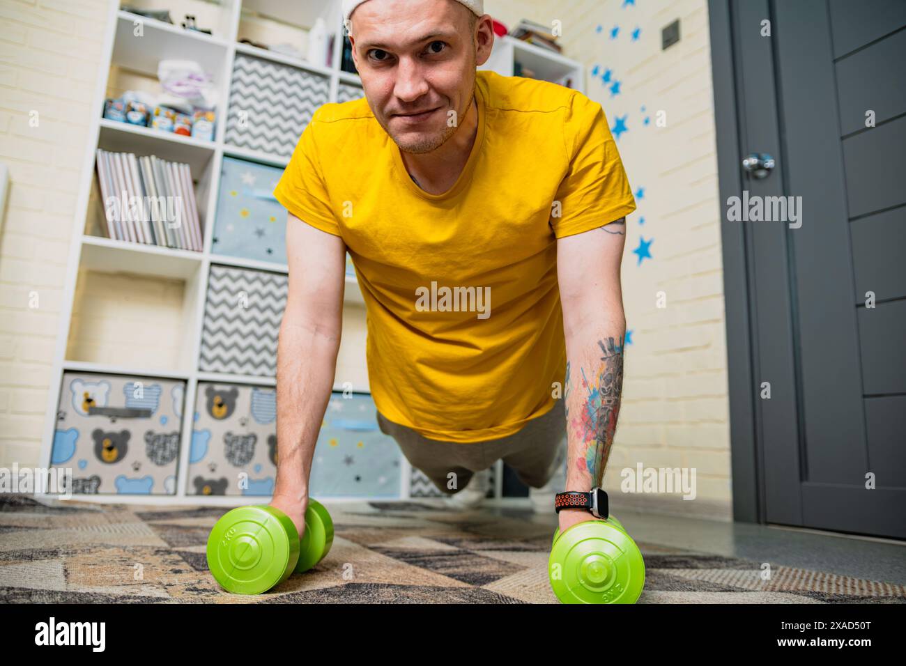 Man Doing Push Ups With Dumbbells At Home Stock Photo