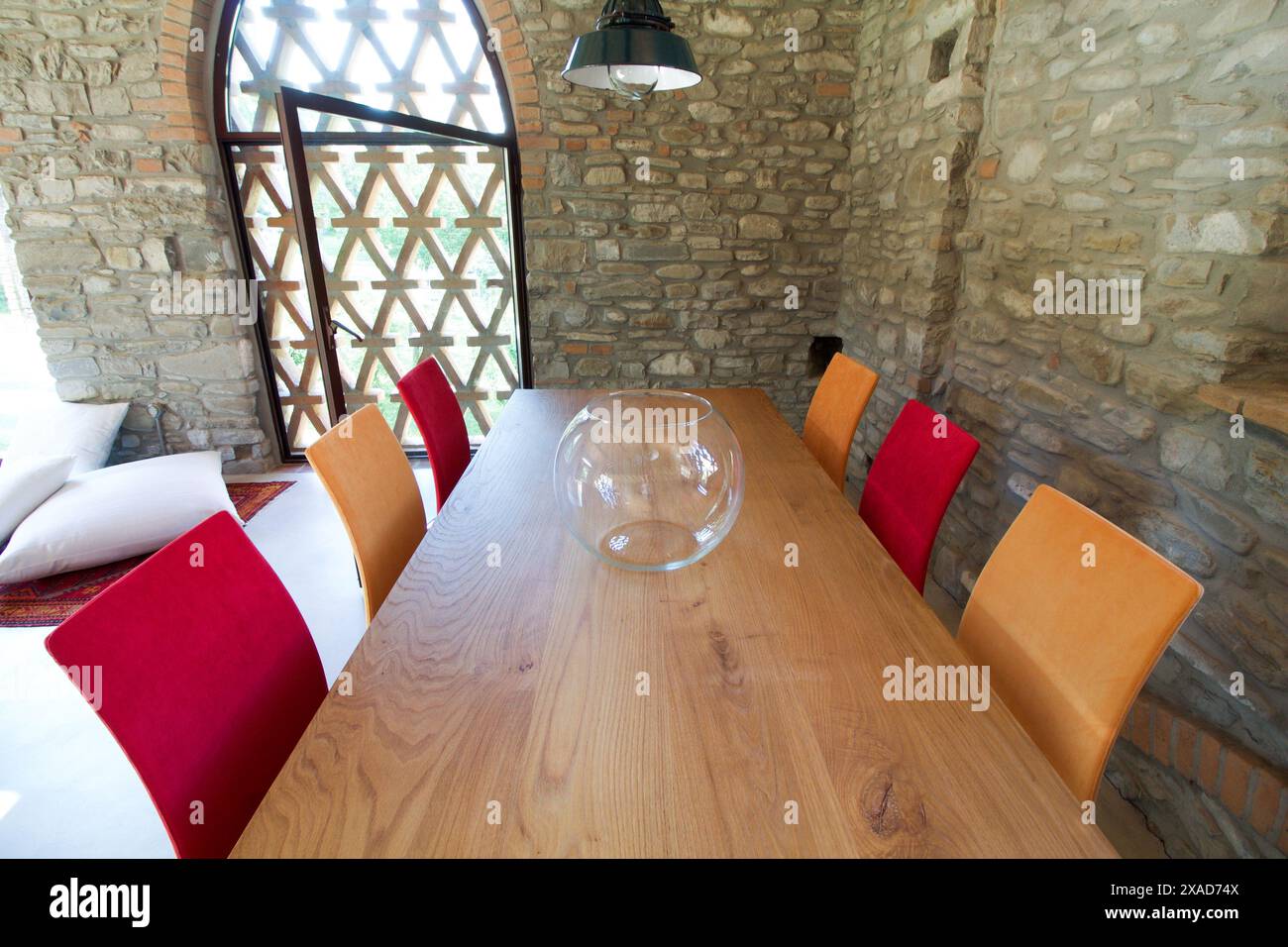 large wooden table with colored chairs in a rustic loft Stock Photo - Alamy