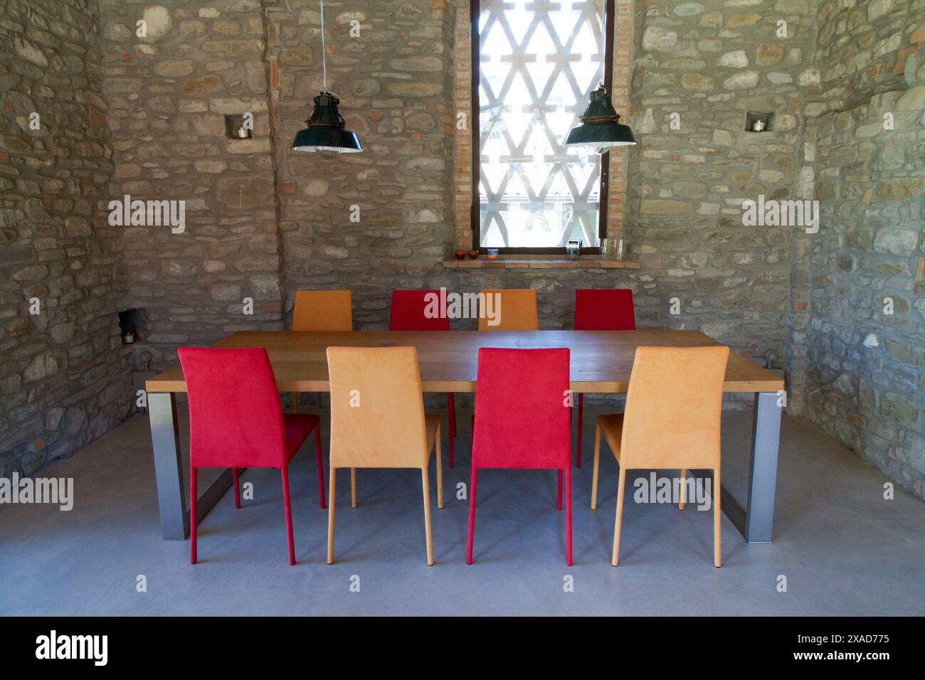 table with colored chairs in a rustic loft Stock Photo