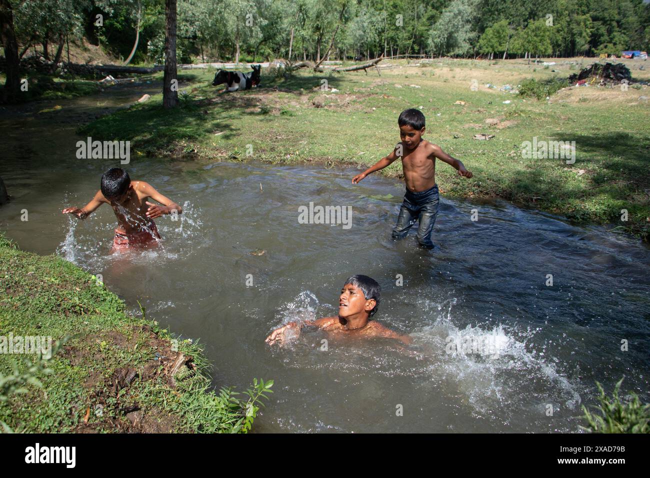 Srinagar, Jammu And Kashmir, India. 6th June, 2024. Young nomadic children are bathing in a stream to find relief from the heat on a hot summer day on the outskirts of Srinagar. (Credit Image: © Adil Abass/ZUMA Press Wire) EDITORIAL USAGE ONLY! Not for Commercial USAGE! Stock Photo