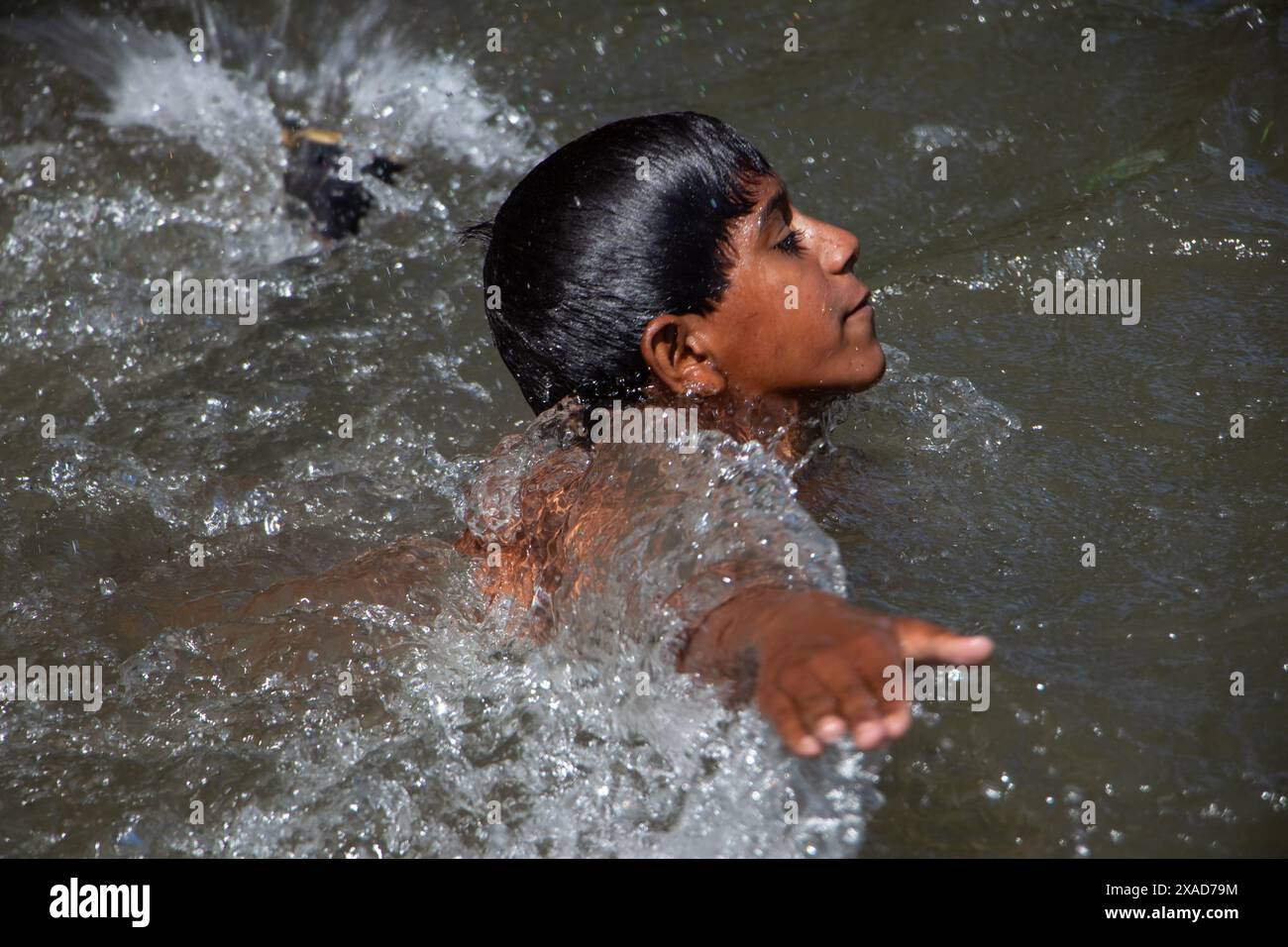 Srinagar, Jammu And Kashmir, India. 6th June, 2024. A young nomadic boy is taking a bath in a stream to seek relief from the heat on a hot summer day on the outskirts of Srinagar. (Credit Image: © Adil Abass/ZUMA Press Wire) EDITORIAL USAGE ONLY! Not for Commercial USAGE! Stock Photo