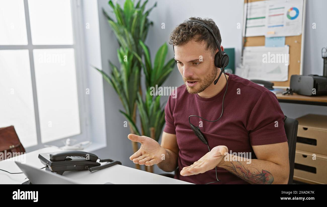 Hispanic man with beard using headset in modern office setting, communicating with clients as customer support representative. Stock Photo