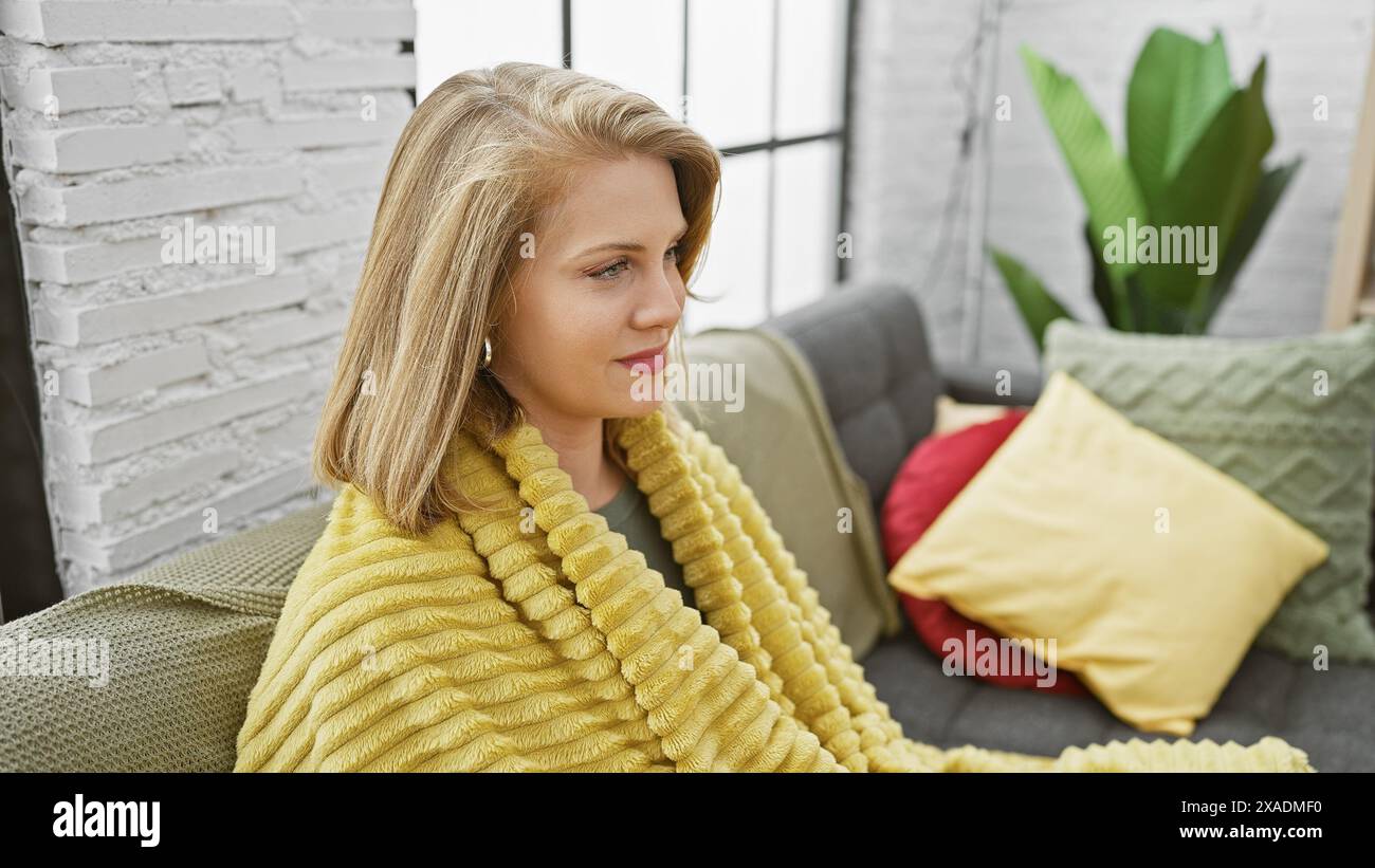 A serene young woman with short blonde hair relaxes on a sofa in a cozy ...