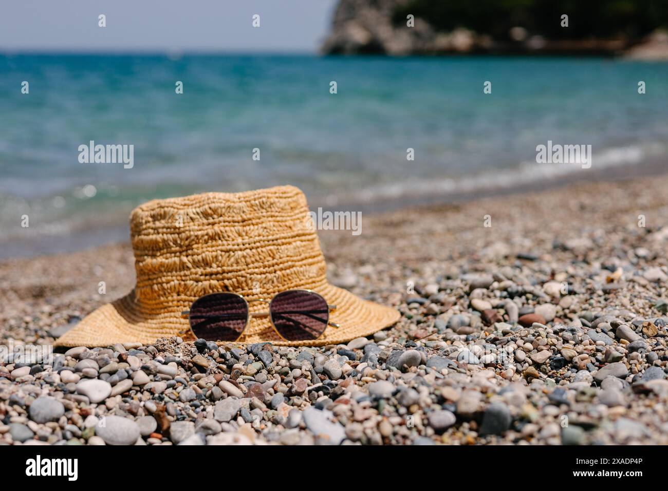 Straw hat and sunglasses on the seashore Stock Photo - Alamy