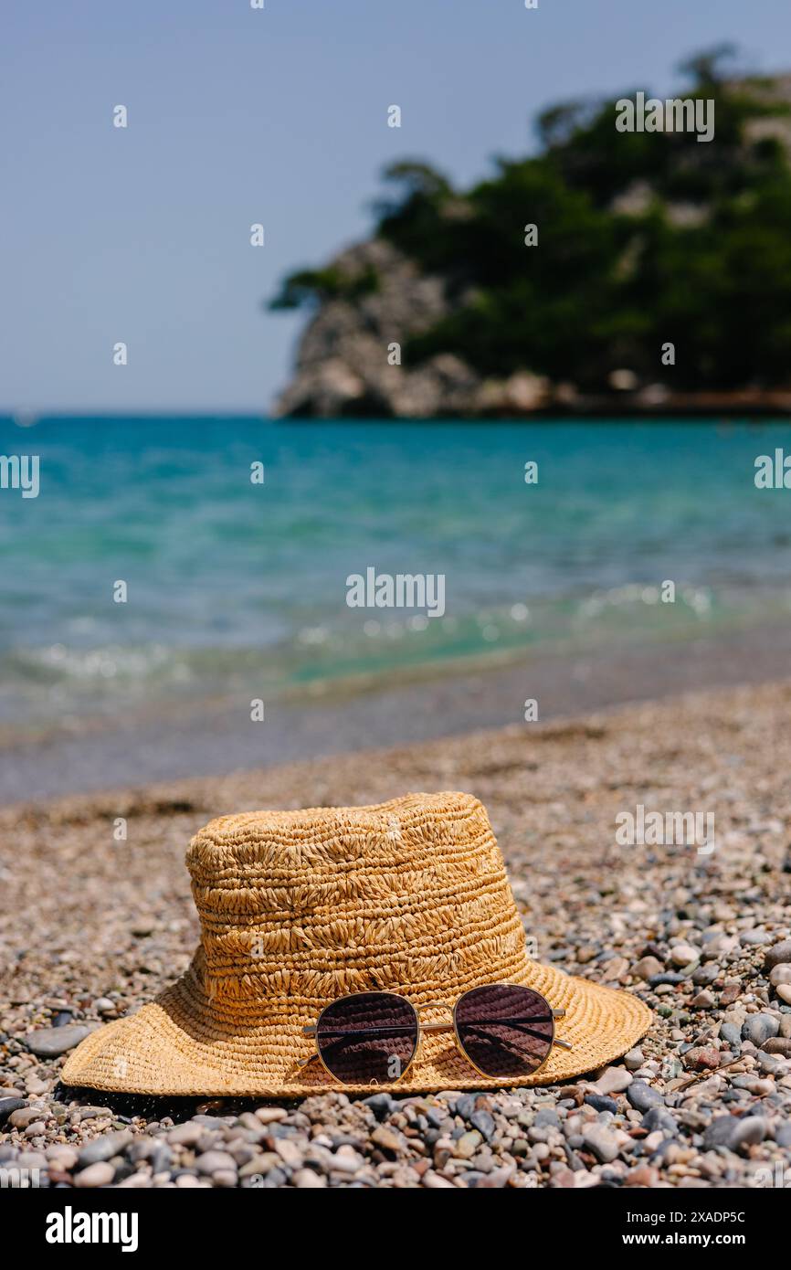 Straw hat and sunglasses on the seashore Stock Photo - Alamy