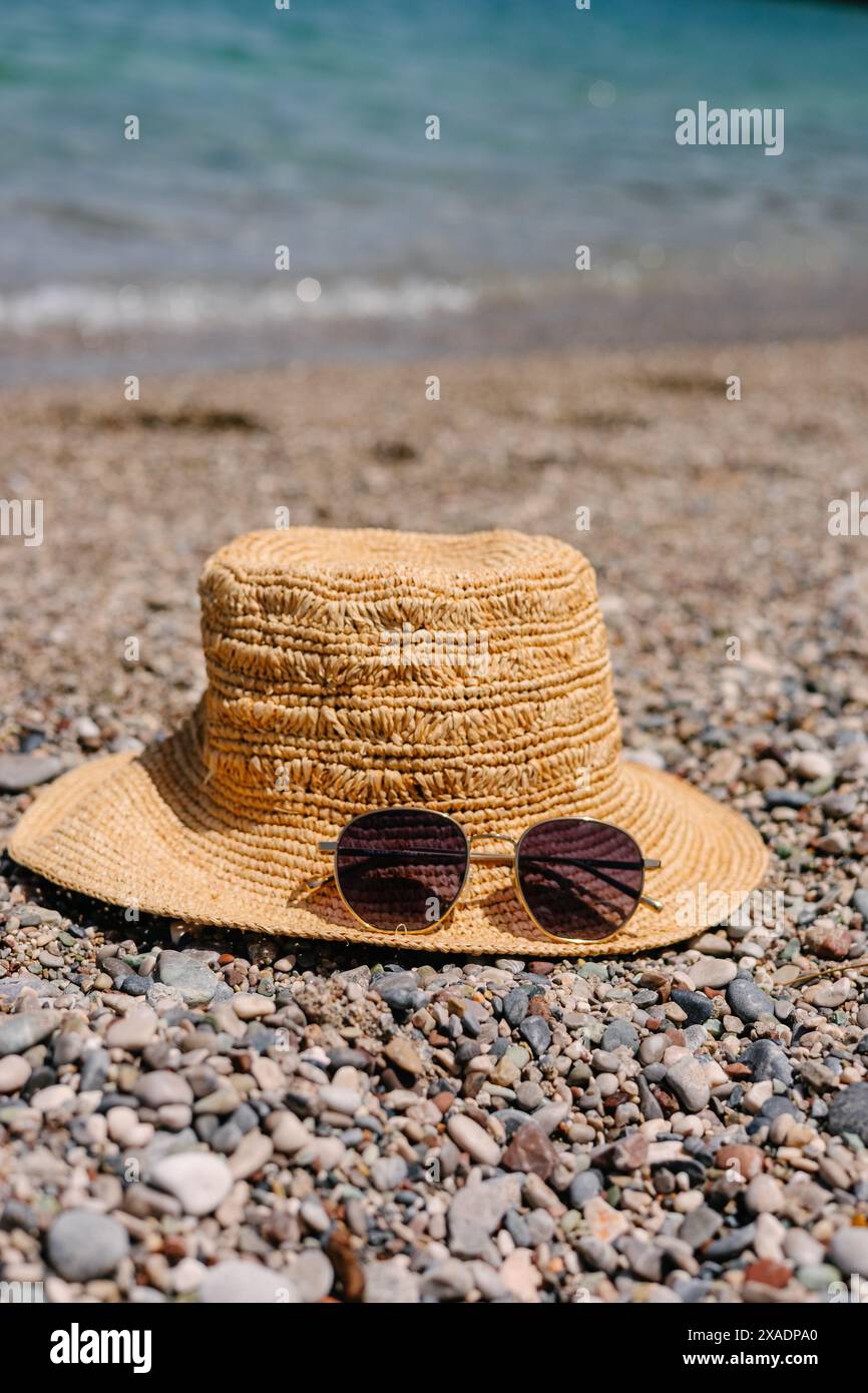 Straw hat and sunglasses on the seashore Stock Photo - Alamy