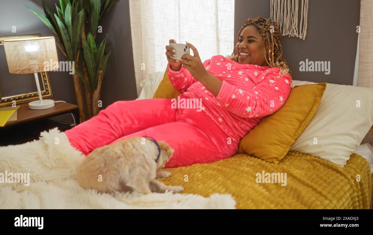 A young african american woman with braids lounges on a bed in a cozy ...