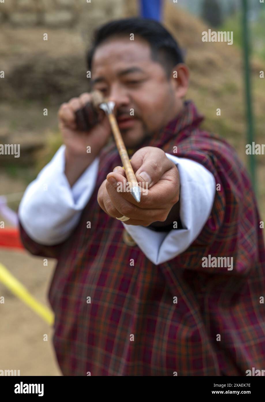 Bhutanese archer looking at an arrow during a competition, Chang Gewog, Thimphu, Bhutan Stock Photo