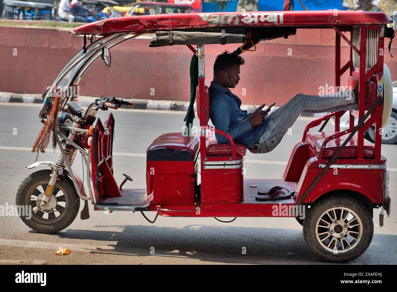 Delhi, India: Street scene in the old city centre of Delhi. Rickshaw driver on the phone waiting for customers Stock Photo