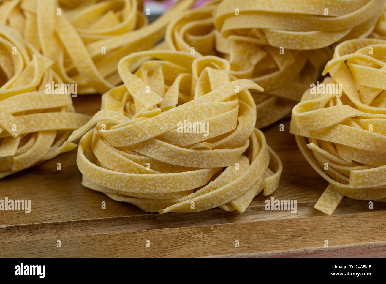 raw tagliatelle pasta on a cutting board Stock Photo
