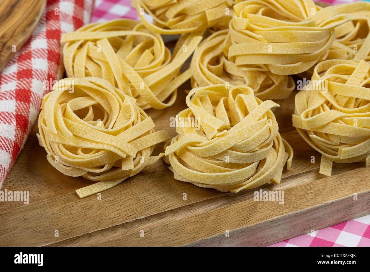 raw tagliatelle pasta on a cutting board Stock Photo