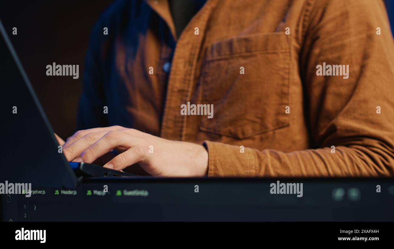 Programmer concentrating on writing complex binary code scripts on laptop terminal, close up shot. Teleworking IT specialist standing in home office, using programming to safeguard consumer data Stock Photo