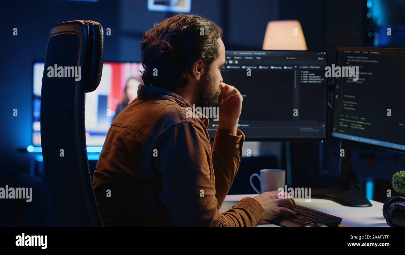 Stressed engineer feeling pressed by deadline, thinking how to finish developing code on PC. IT specialist brainstorming ways of solving database errors, working hard, drinking coffee, camera A Stock Photo