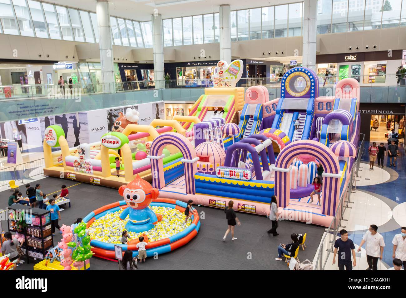 Inside a spacious shopping mall interior. A huge bouncy castle is set ...