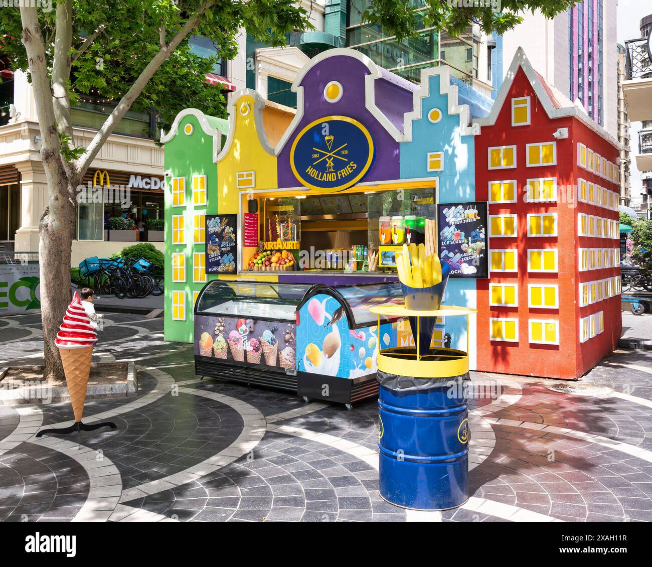 Baku, Azerbaijan - May 5, 2024: Colorful food kiosk on Nizami Street, featuring a Holland Fries sign and various food items displayed Stock Photo