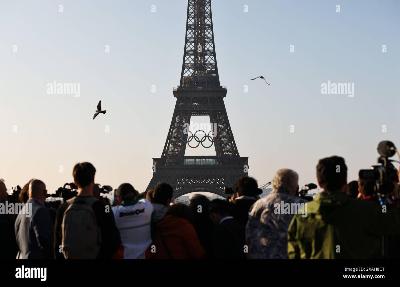 Paris, France. 7th June, 2024. People watch the Olympic rings on the Eiffel Tower, in Paris, France, on June 7, 2024. The Olympics rings are unveiled on the Eiffel Tower early in the morning of Friday as the French capital marks 50 days until the start of the upcoming Paris 2024 Olympic Games. Credit: Gao Jing/Xinhua/Alamy Live News Stock Photo