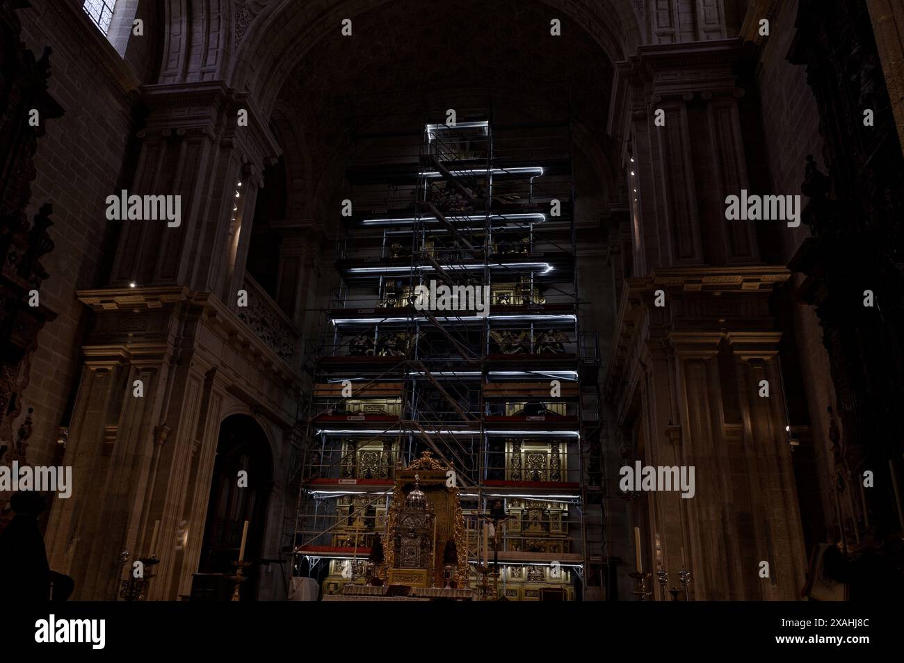 Lit scaffolding surrounds the intricate altar of a historic cathedral as restoration work is underway Stock Photo