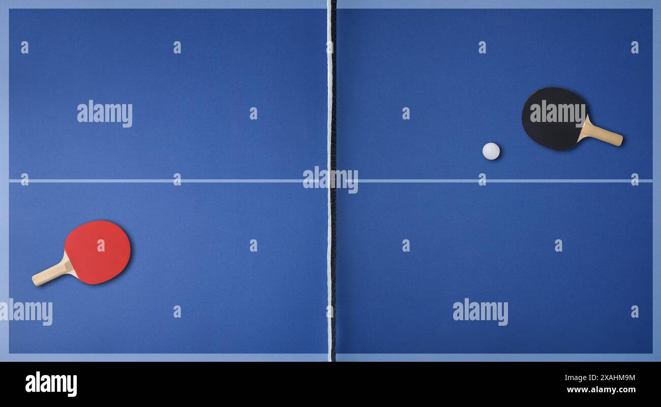Top view of professional blue ping pong playing surface with paddles on