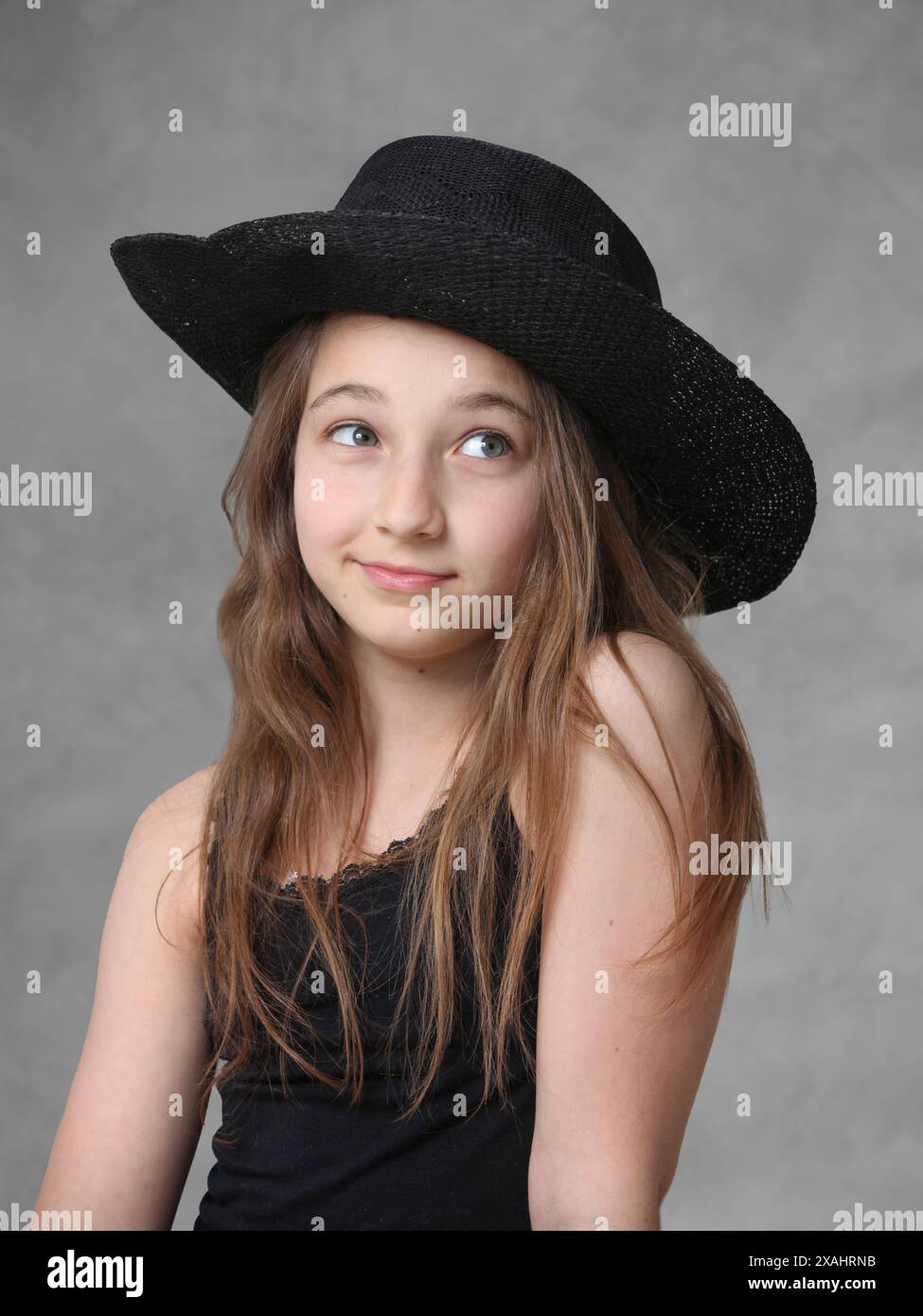 cute cheerful preteen girl with long hair wearing a hat Stock Photo - Alamy