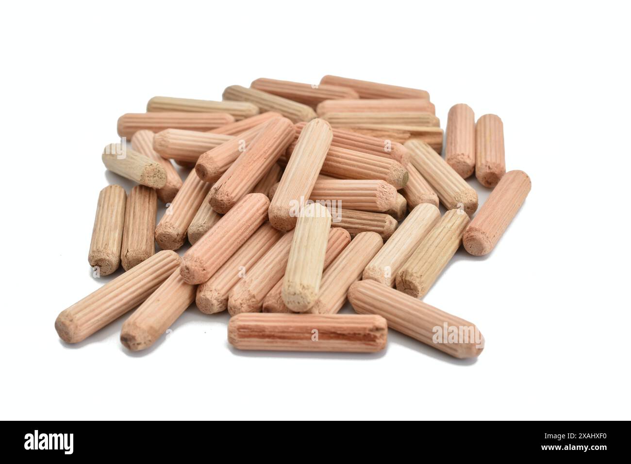 In the photo, dowels made of wood used in furniture production are lying in a heap. Stock Photo