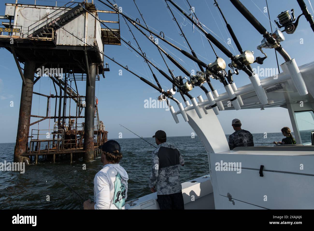 Anglers fish for baitfish while surrounded by offshore oil platforms in ...