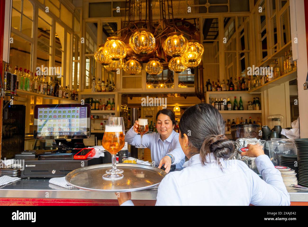 Palma, Balearic Islands, Spain, Waitress recieving a mug of draft beer from a bartender,  Editorial only. Stock Photo