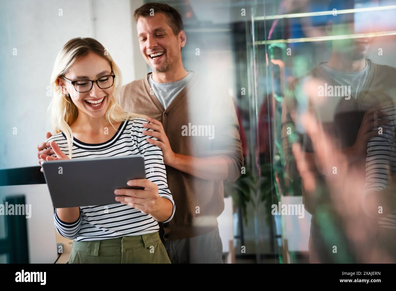 Two young businesspeople using a digital tablet while standing in a boardroom. Stock Photo