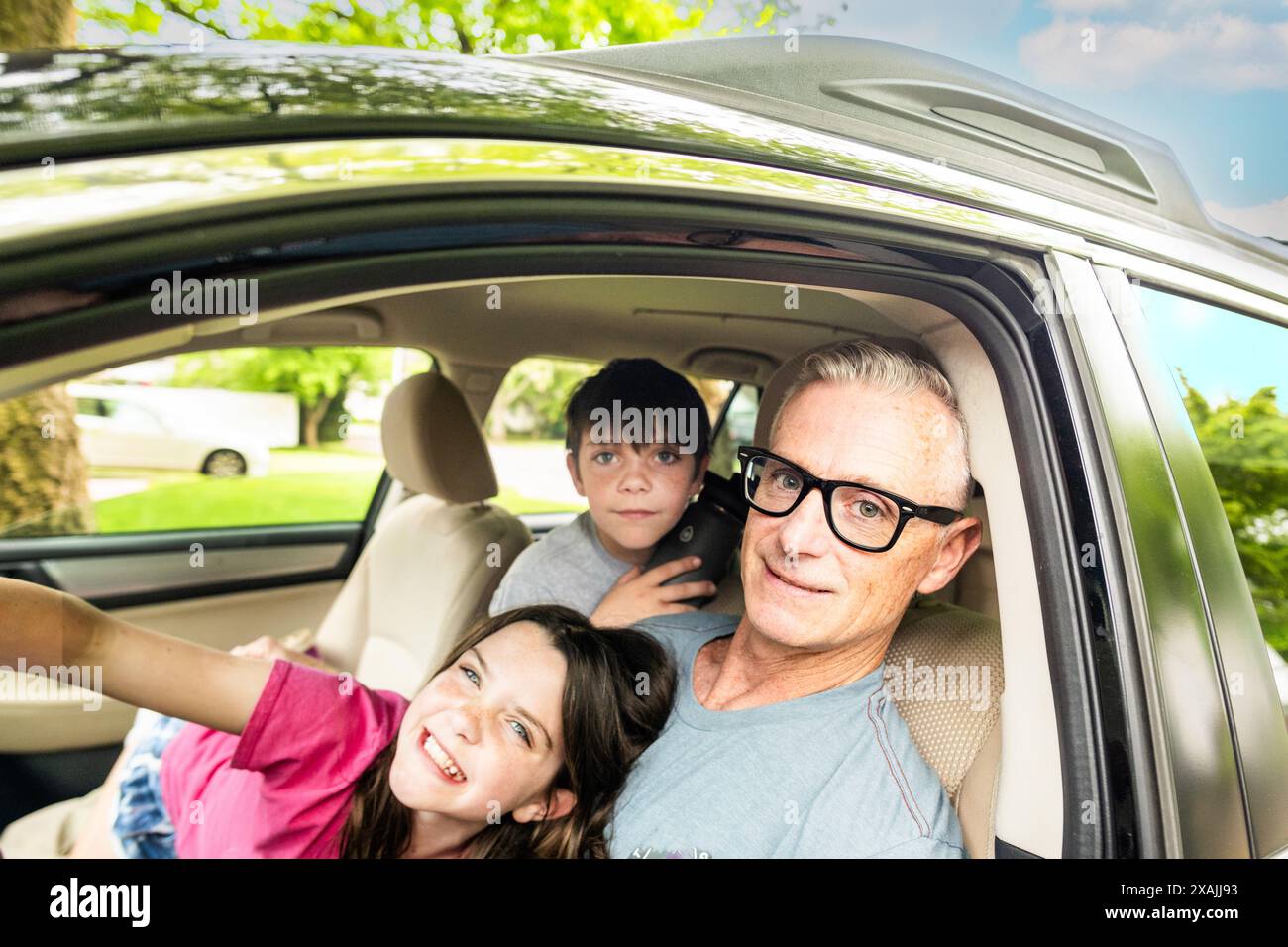 Dad and kids in car waiting in driveway Stock Photo - Alamy