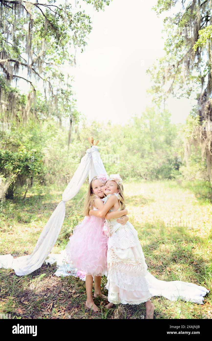 Two girls hugging in a garden with lace canopy Stock Photo - Alamy