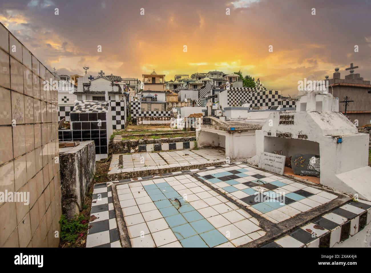 Famous cemetery, many mausoleums or large tombs decorated with tiles, often in black and white. Densely built buildings under a sunset Cimetiere de Morne-a-l'eau, Grand Terre, Guadeloupe, Caribbean Stock Photo