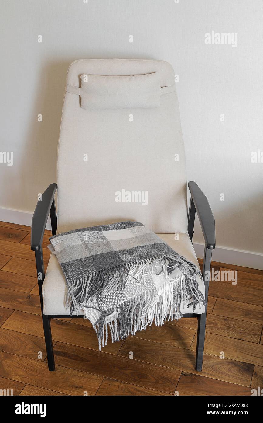 Armchair with blanket in the living room interior Stock Photo - Alamy