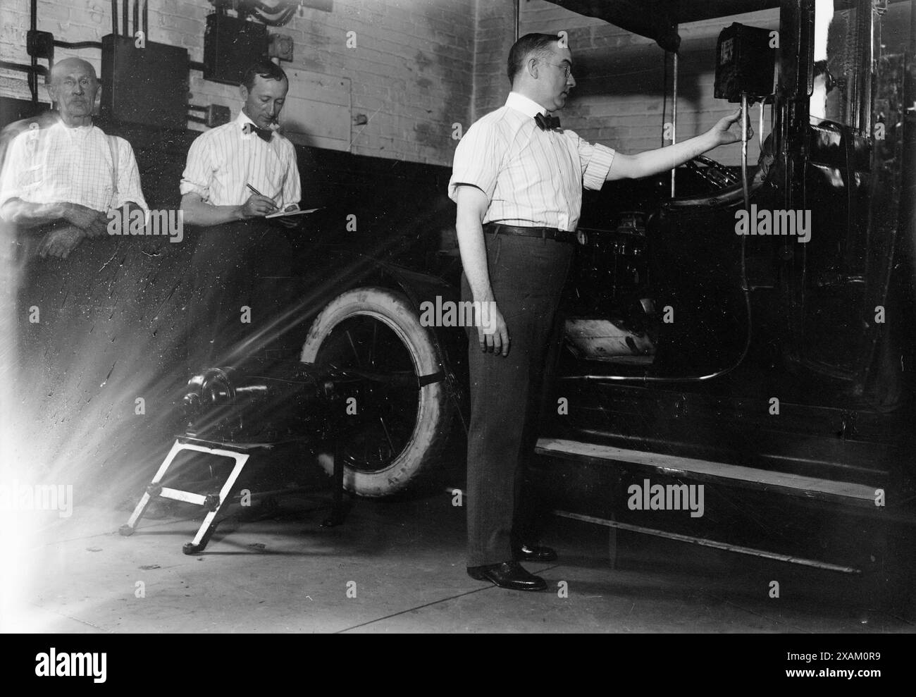 John Drennen inspecting meter, 1913. Shows John Drennen of the New York City Mayor's Bureau of Licenses inspecting a taxicab meter after new ordinance regulating meters went into effect on August 1, 1913. Stock Photo