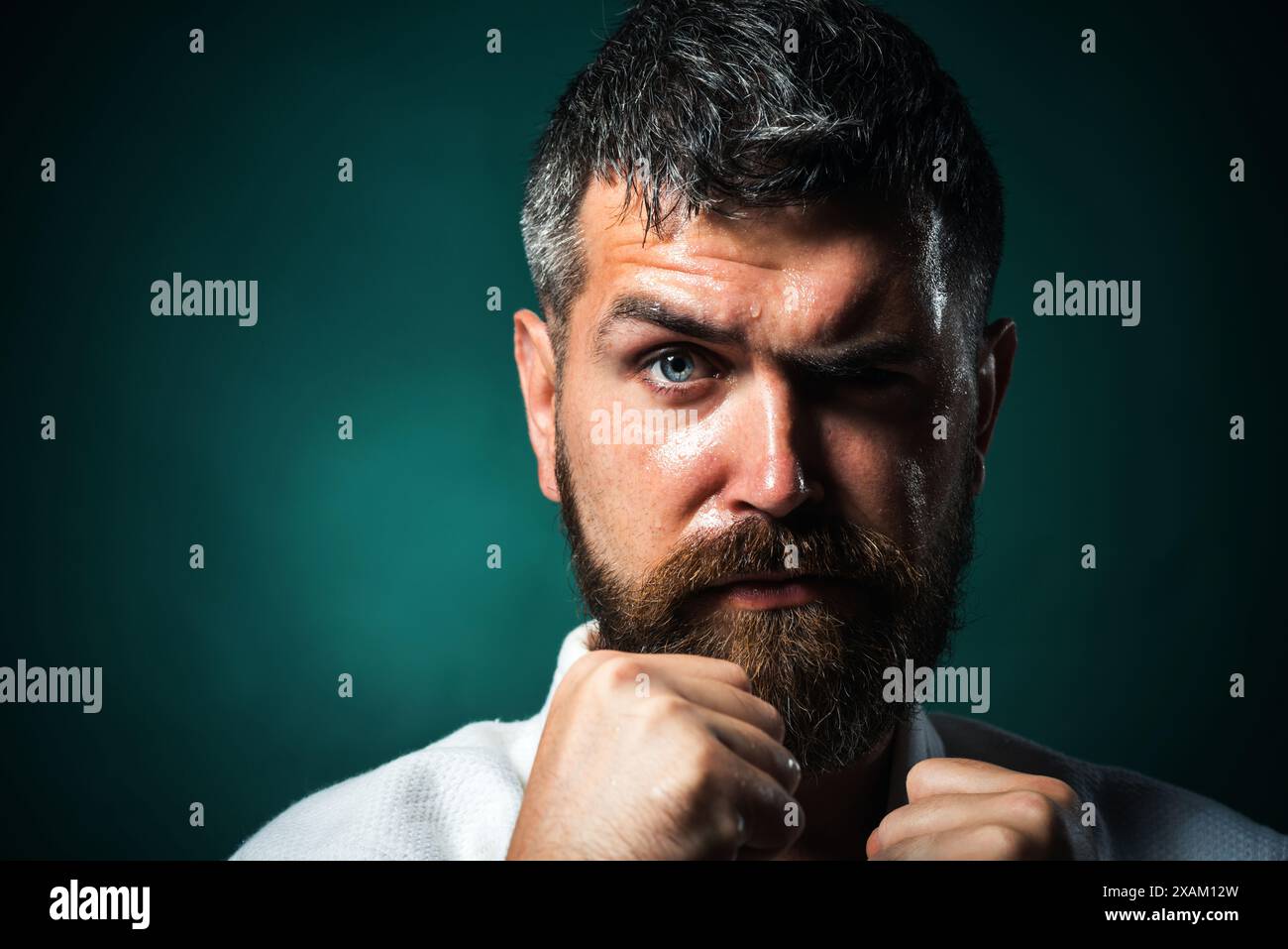 Closeup portrait serious karate man in fighting position. Male karate instructor with clenched fists. Muscular fitness model ready for karate training Stock Photo