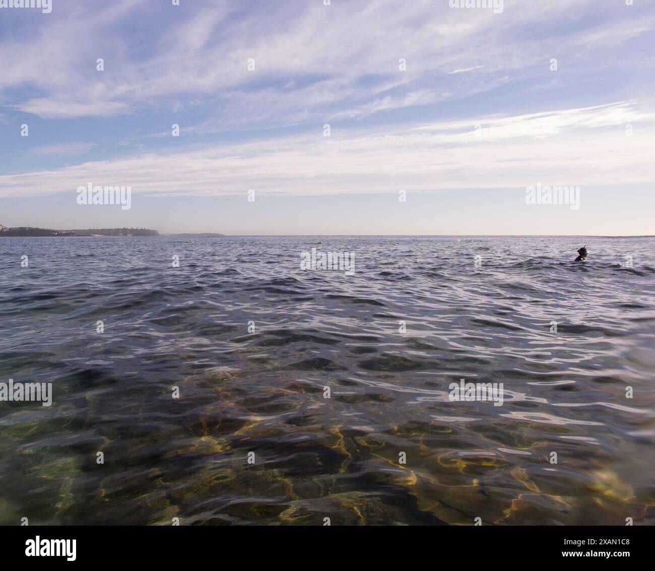 Sun light rays beaming into the blue green water and highlighting the ...