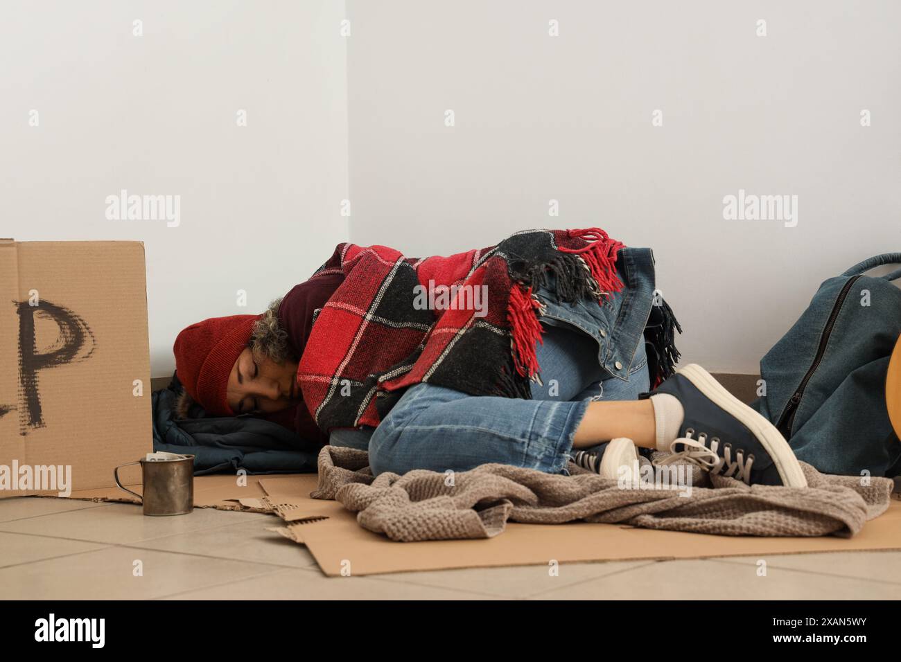 Mature homeless woman sleeping on cardboard in corner Stock Photo - Alamy
