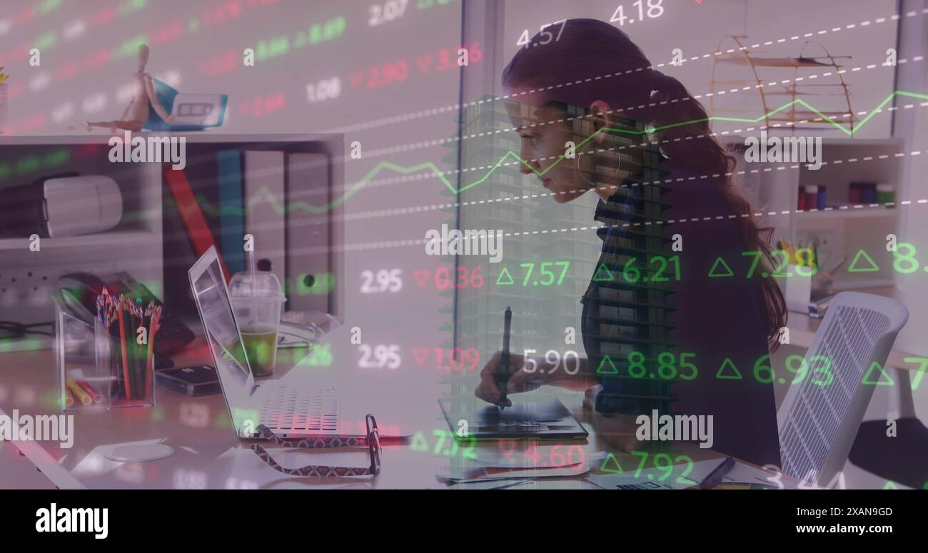 Image of financial data processing over caucasian businesswoman using laptop at office Stock Photo