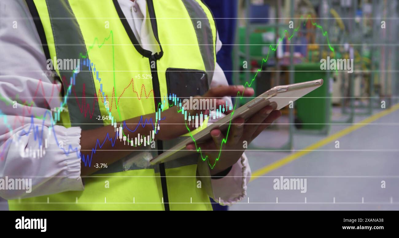 Financial data processing against mid section of engineer using digital tablet at factory Stock Photo