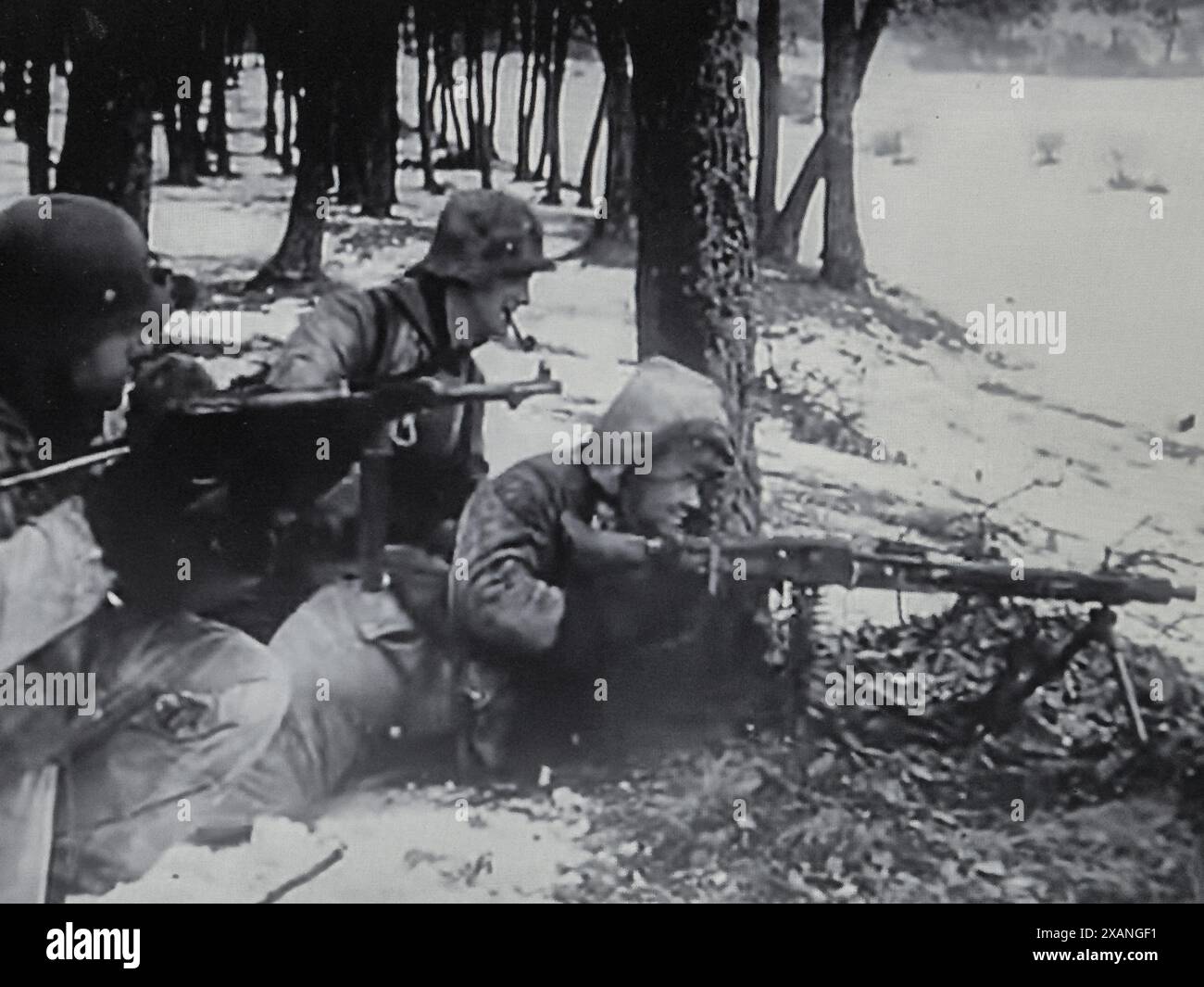 World War Two B&W Screenshot . Waffen SS men from the Wiking Division take up position with MG on the edge of a wooded area in Hungary February 1945 Stock Photo