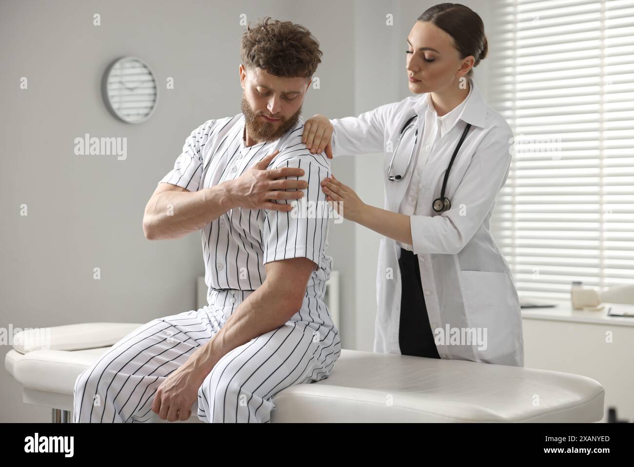 Sports injury. Doctor examining patient's shoulder in hospital Stock ...