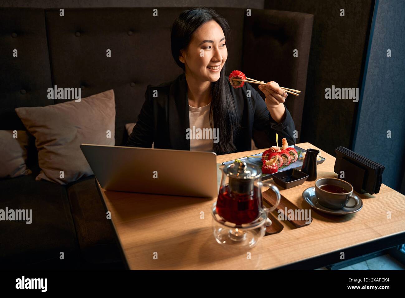Asian lady having lunch before online video conference Stock Photo