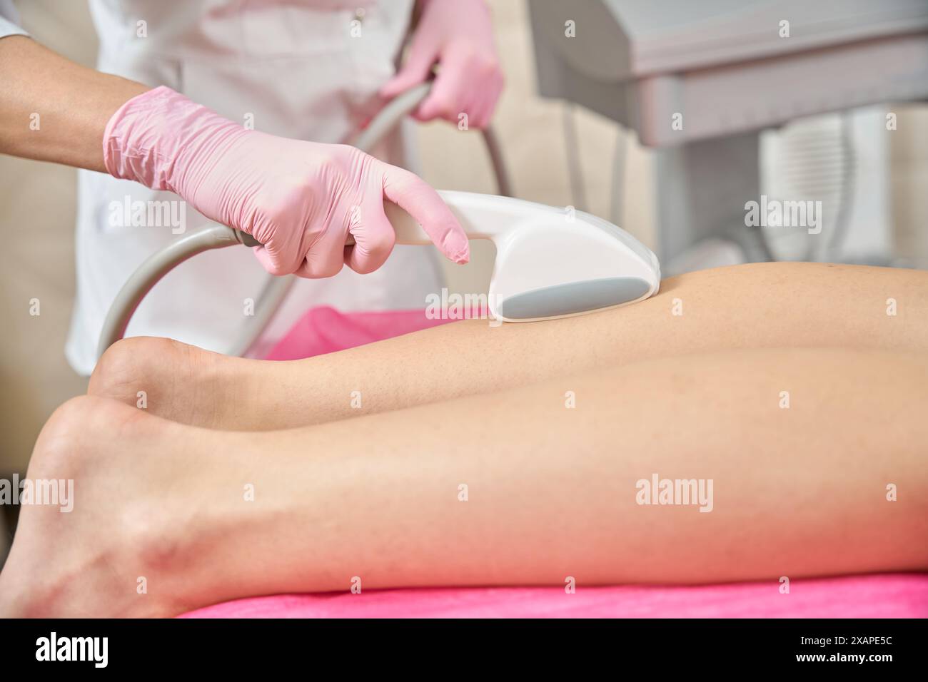 Beautician performing skin tightening procedure on client lower leg ...