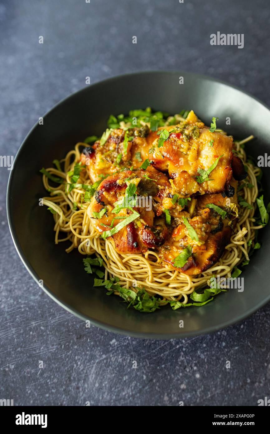 Sweet chilly chicken thighs with noodles Stock Photo - Alamy