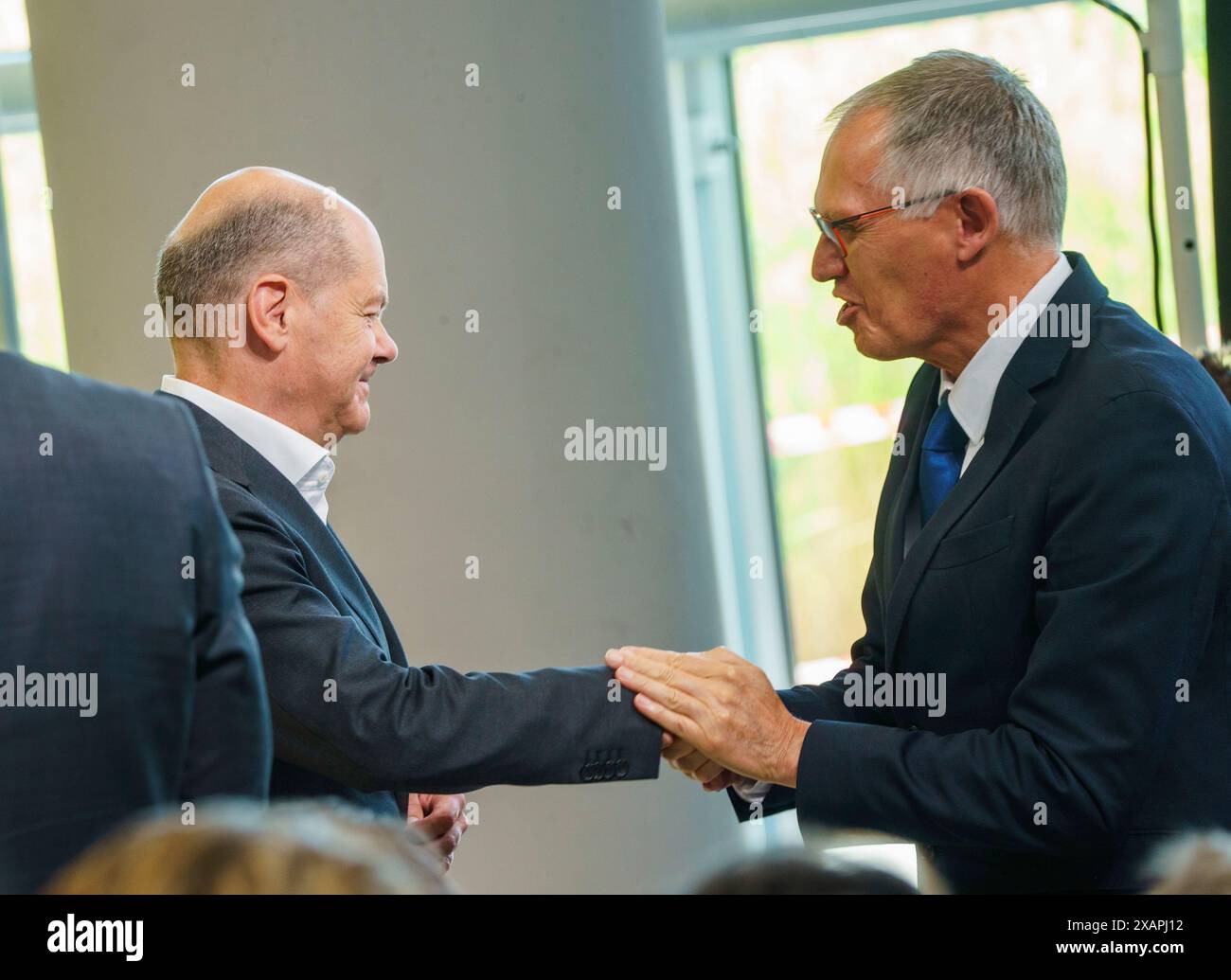 08 June 2024, Hesse, Rüsselsheim: German Chancellor Olaf Scholz (SPD, l